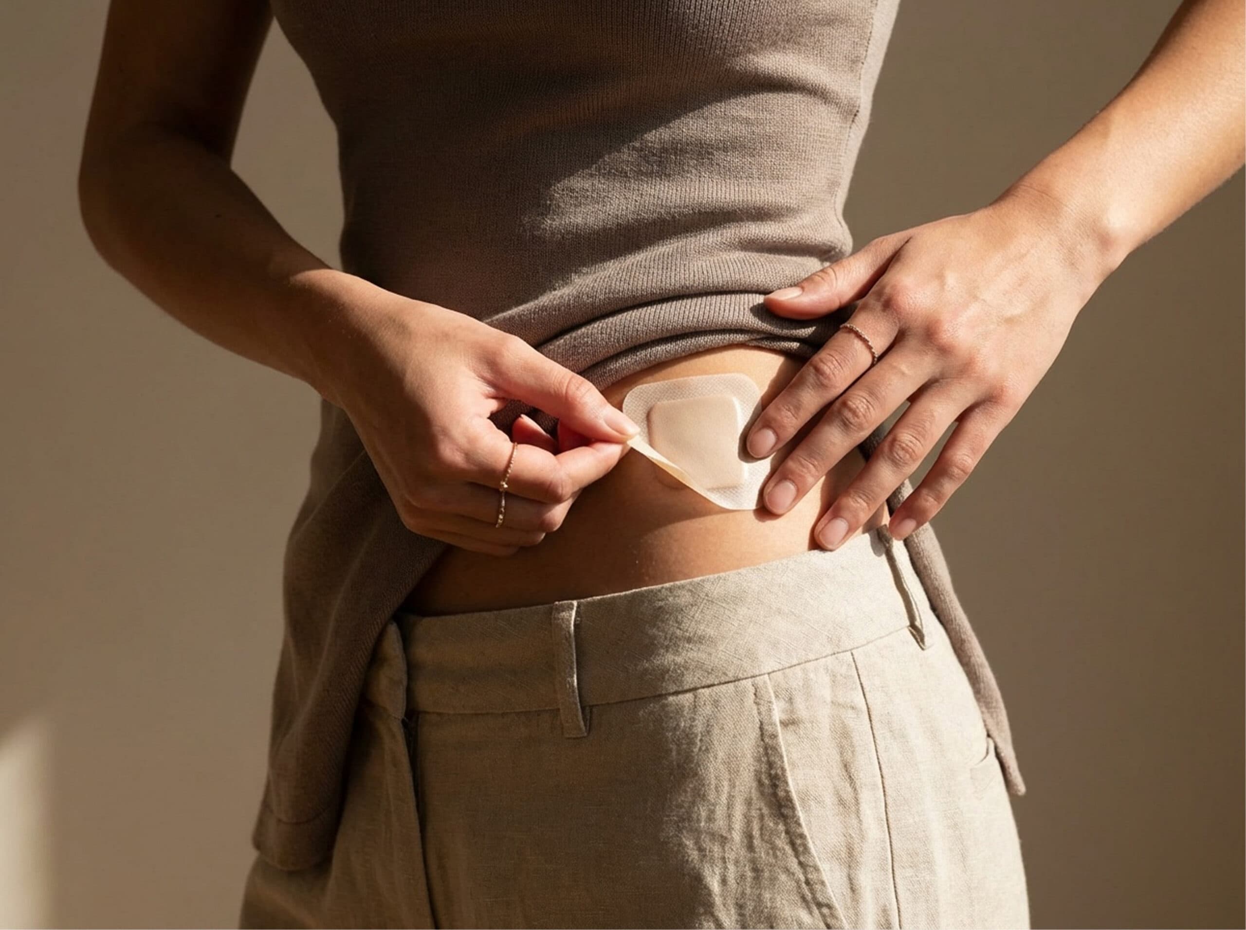 A person placing a patch on their hip